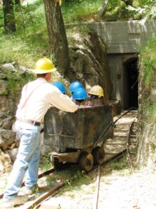 Author Greg Smith pushing mine car into gold mine in Julian, CA